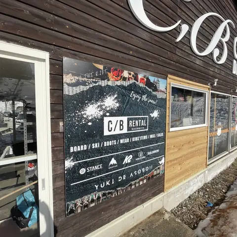 C,B cafeの看板がある木造外壁に、黒いレンタル看板を掲出した様子